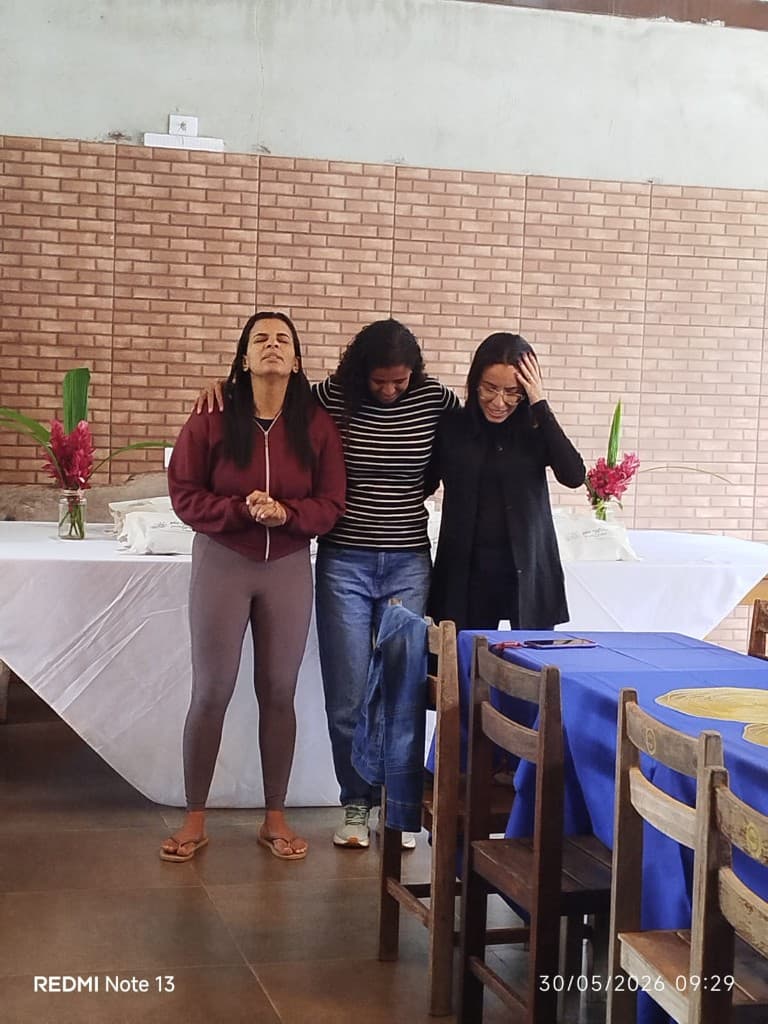 Mulheres em oração, uma ao lado da outra